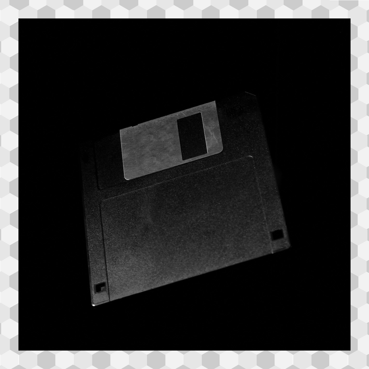 image of a black 3.5" floppy disk with a black background and hexagon border